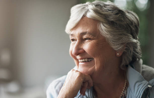 istock Happy. thinking and elderly woman in her room with a dreaming or memory expression at her house. Smile, brainstorming and senior female person with an idea, solution or plan in a retirement home. 1502897400