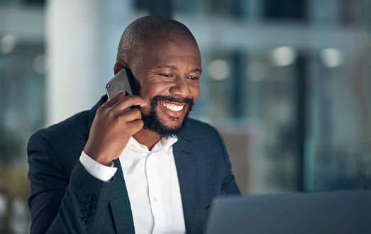 Mature business man, night and phone call in office, smile or laptop for networking, stock market or research or. African investor, smartphone and computer for working late, communication and finance