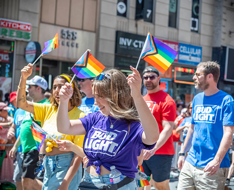 Toronto, Ontario, Canada - June 24, 2023: A lady waving two pride flags during Toronto's annual Pride parade.water bottle