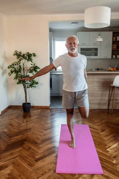 istock Fit senior man exercising at home doing lunges exercise. Mature man stretching at home. 1502901576
