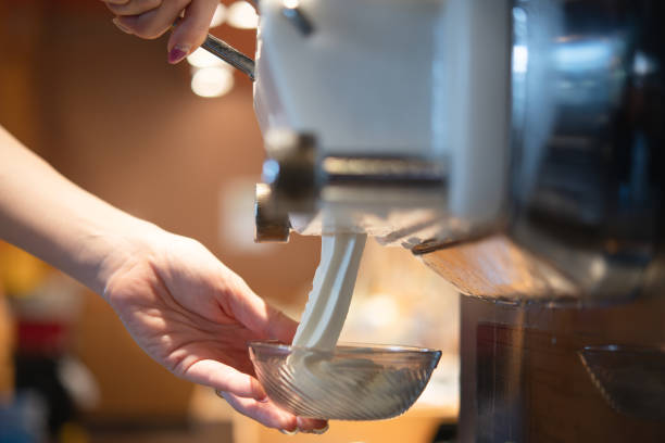 una mano di donna che serve la panna morbida - frozen sweet food foto e immagini stock