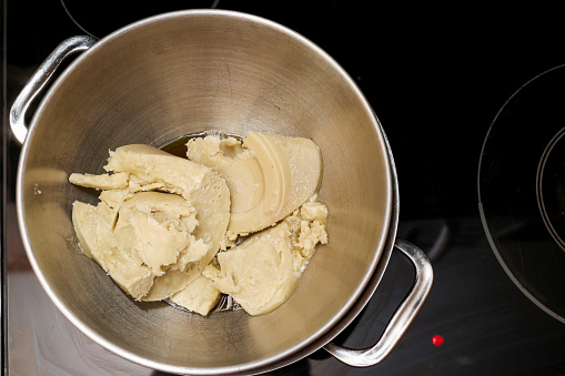 Organic raw African Shea Butter melting in a double boiler on a stove