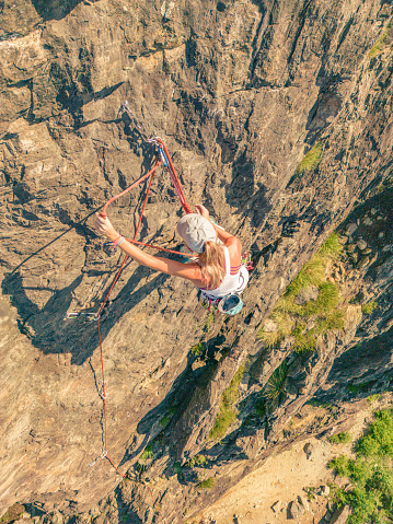 Young woman rock climbing on steep wall