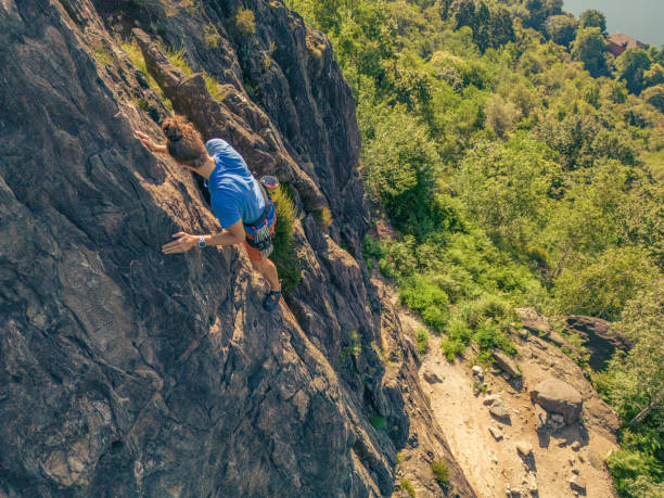 istock Man rock climbing in summer on steep wall outdoors 1502909631