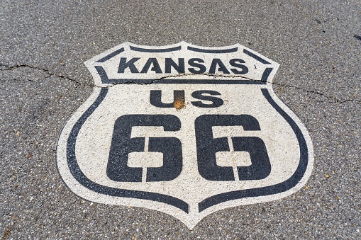 Holbrook, Arizona, United States - September 19, 2023:  Gillespie Park in Holbrook, Arizona  with the Route 66 sign and a bronze statue of a Hashknife Pont Express Rider carrying U.S. Mail