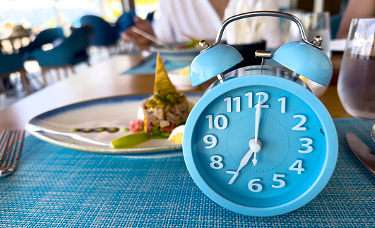 Blue alarm clock with IF (Intermittent Fasting) 16 and 8 diet rule and weight loss concept.-Diet plan concept