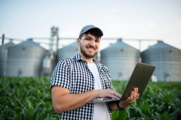 istock Portrait of a smiling farmer in the corn field using laptop. 1502921562