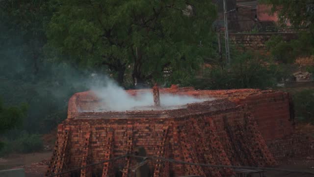 Smoke arising from the brick kiln used to prepare bricks in the villages of India. Smoke causes too much global warming and kiln releases too many harmful gases. Rural India background with copy space