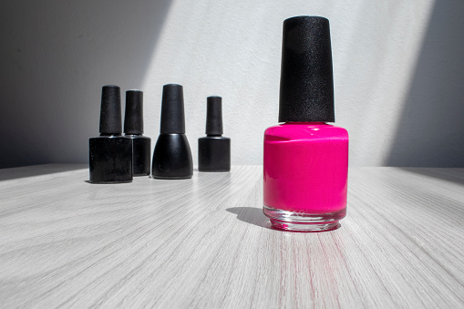 Nail Polish. A Bottle of Pink Nail polish on a Plain Background with Space for Text.