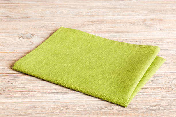 istock top view with green kitchen napkin isolated on table background. Folded cloth for mockup with copy space, Flat lay. Minimal style 1502932983