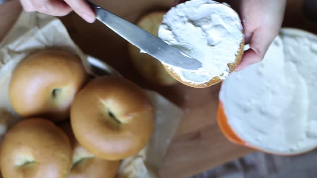 Closeup of Spreading Cream Cheese on a slice of Bagel bread