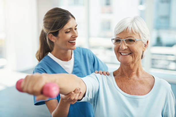 femme âgée, médecin et aide à l’haltérophilie pour l’exercice physique ou l’activité à l’hôpital. infirmière, thérapeute ou médecin heureux aidant la dame âgée à s’entraîner ou à s’entraîner à la clinique - sentraîner photos et images de collection