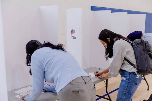 istock Standing in private booths, voters write on ballots 1502936652