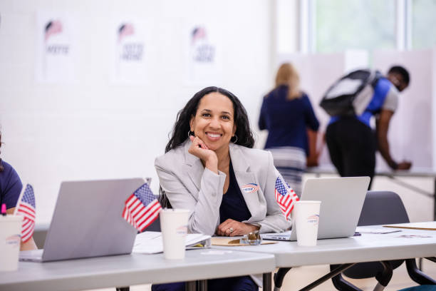 istock Smiling female polling place volunteer rests head on hand 1502936676