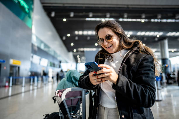 istock Young woman using phone at the airport 1502939557