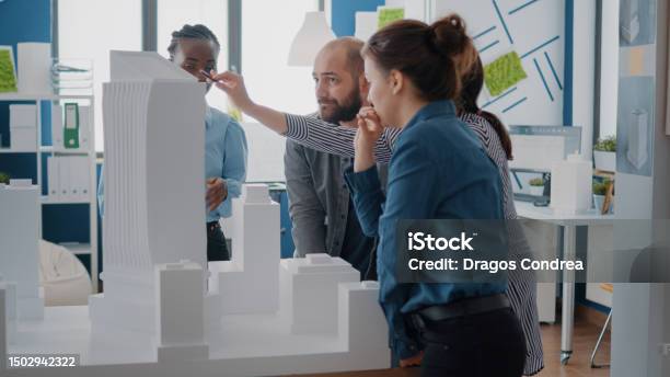 Multi Ethnic People Working With Building Model To Design Urban ...