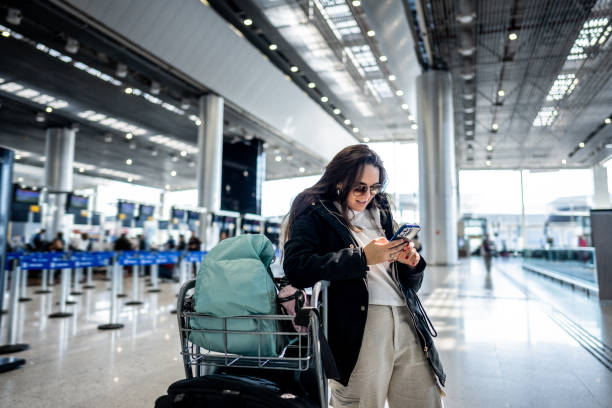 istock Young woman using phone at the airport 1502942911