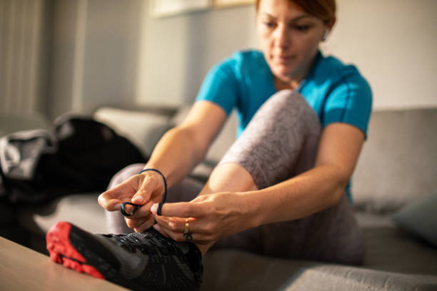 istock Young woman tying her shoelaces and getting ready to go exercise 1502943387