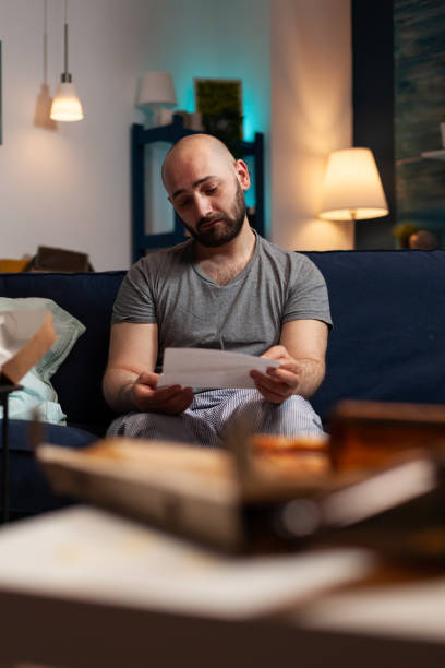 istock Anxious frustrated depressed young man reading letter 1502945161