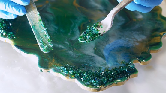 procedure of embellishing a green resin product by applying glitter