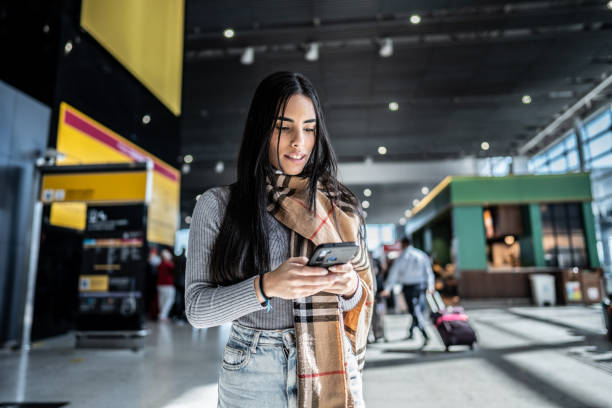 istock Young woman using phone at the airport 1502945300