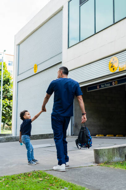 istock Doctor is going to pick up his son from school while he comes wearing his clinic uniform 1502945454