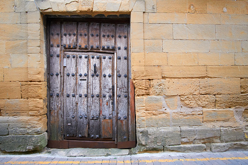 Millennial wooden door and stone facade with copy space