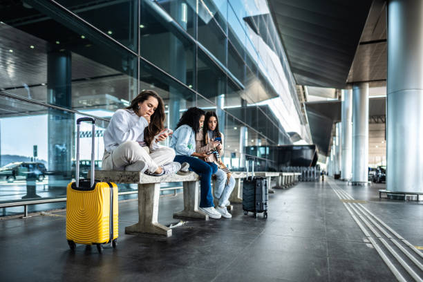 istock Friends using phone while waiting at the airport 1502945717