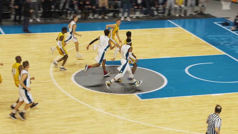 College Basketball Tournament TV Playback: Two Young Successful Diverse Teams Play a Championship Match in a Crowded Arena. Excited African Player Scores a Slam Dunk with One Hand and Celebrates