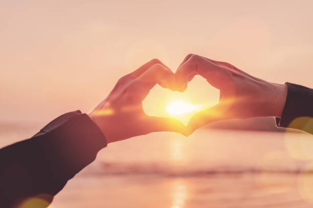 istock Female hands heart shape on nature bokeh sun light wave and blur tropical sunset beach abstract background. Copy space of happy love travel and freedom in nature concept. Vintage tone color style. 1502946791