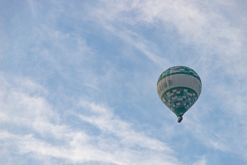 Colorful hot air balloons flying high in the sky at a Balloon Festival in the fall near Albuquerque, New Mexico.