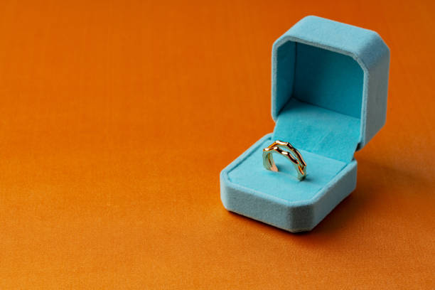 istock Golden ring in jewelry box on orange background 1502953034