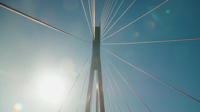 Bridge support with ropes in the sun against the blue sky