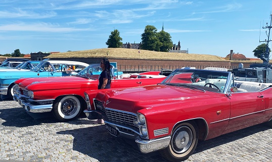 One red Cadillac de ville from 1967 (right), one red Cadillac from 1959 (in the middle), one blue Cadillac (left). Collectors items. The photo was taken on June 10th, 2023 in Helsingør, Denmark.