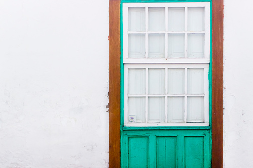 Closed green traditional window on white wall. Lanzarote, Canary islands, Spain.