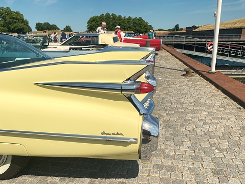 Side view of beautiful yellow classic vintage Cadillac. Classic Cadillacs in a row.  The photo was taken on June 10th, 2023 in Helsingør, Denmark near Kronborg Castle.