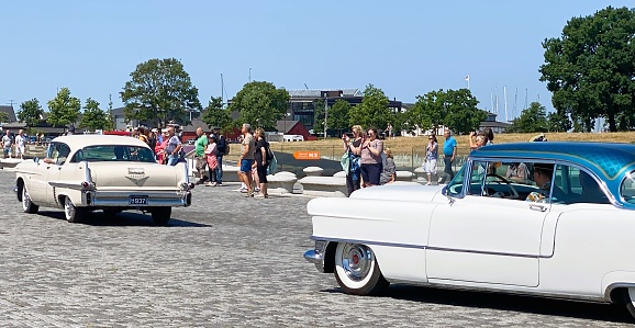 Havana, Cuba – January 20, 2016:  Tourists check out the vintage cars being used as taxis at Plaza de la Revolución (Revolution Square).  