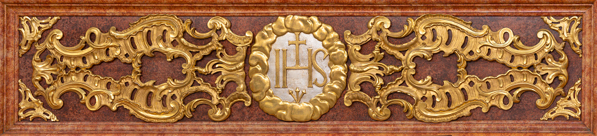 Luzern - The carved polychrome relief of IHS initials of Jesus on the mensa of Jesuitenkirche from 17. cent.