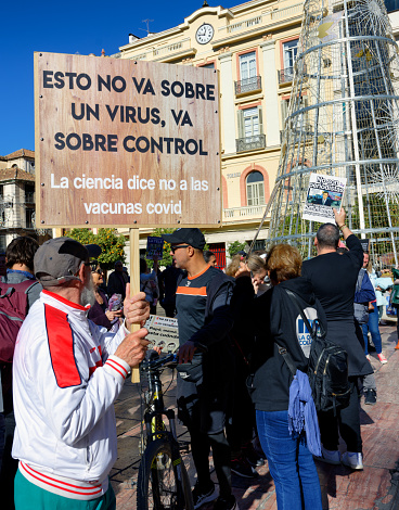 A group of protestors in downtown Malaga, Spain,  march with signs showing their dissatisfaction with COVID restrictions that limit personal freedom.