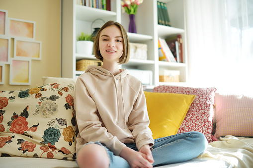 Beautiful teenage girl recording a video blog. Young vlogger shooting vlog at home. Teen influencer creating content for her social media account. Social media and blogging concept.