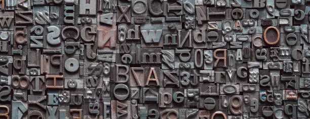 Photo of Letterpress background, close up of many old, random metal letters with copy space