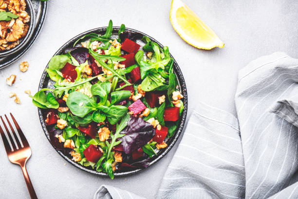 istock Beet salad with arugula, lettuce, chard and walnuts and lemon dressing, gray kitchen table, copy space. Fresh useful vegan dish for healthy eating 1502962465
