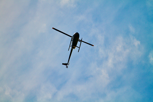 Helicopter Directly Above in Blue, wispy cloud background