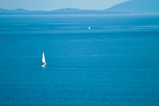 Sailboat on Open Ocean with landscape background
