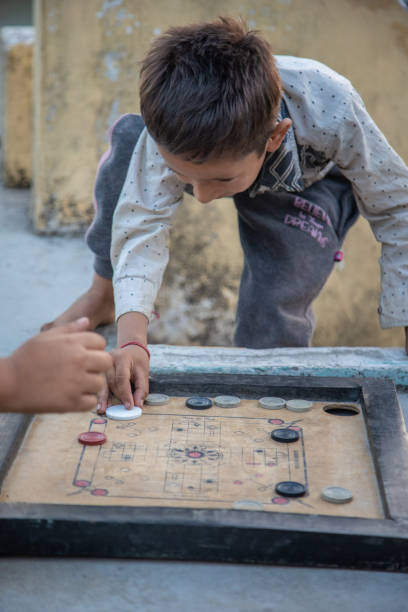istock Young Indian boy kid practicing or playing Carrom board at his village home 1502967339