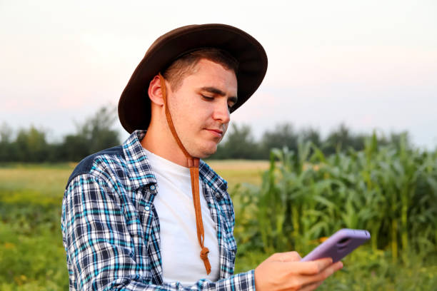istock Farmer using phone. a dedicated farmer stands, attentively examining the crops that have emerged after sowing 1502968855