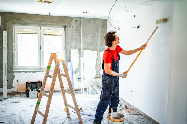 istock Construction worker painting apartment walls with paint roller 1502969287