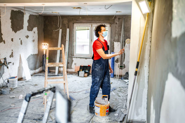 istock Construction worker painting apartment walls with paint roller 1502969289