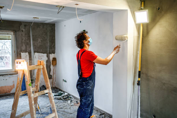 istock Construction worker painting apartment walls with paint roller 1502969290