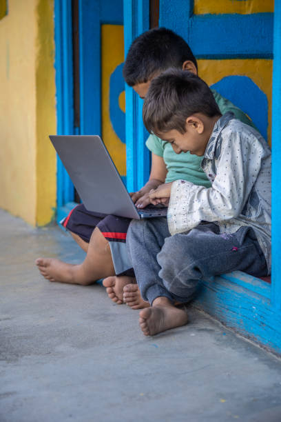 istock Village kids using laptop while sitting on doorway 1502969381